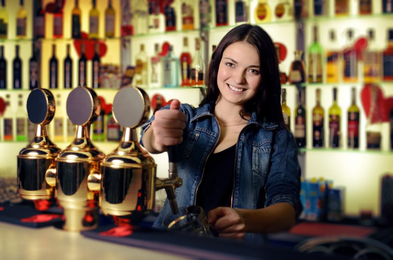 bartender pours beer from tap