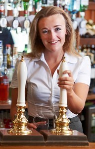 female bartender serving alcohol from a beer tap