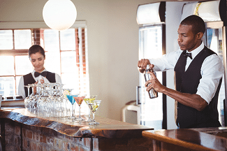 Two bartenders mixing drinks