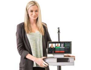 Person standing next to a Patronscan identification scanner smiling on a white background.