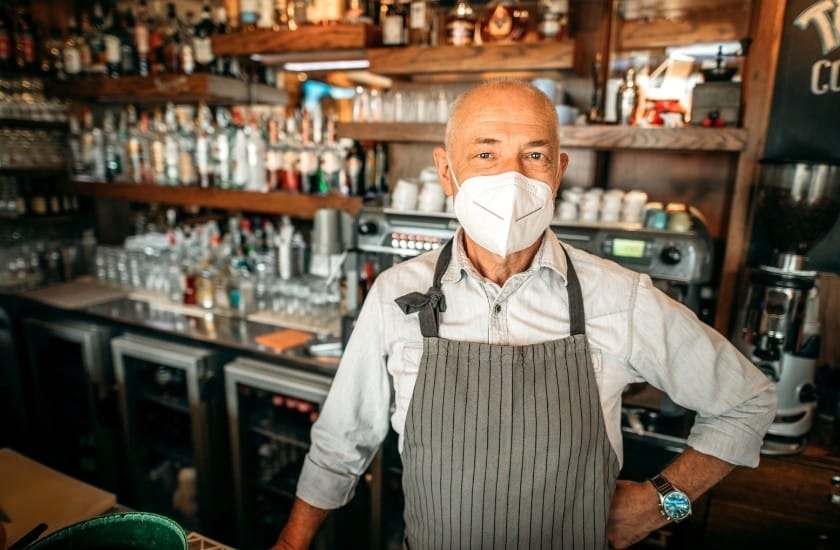 bar owner with mask behind the bar
