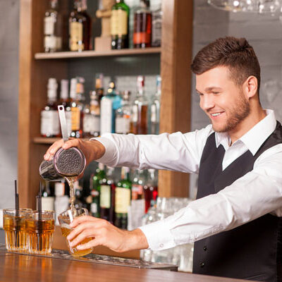Attractive male bartender is making cocktail in bar, Bartending Tips