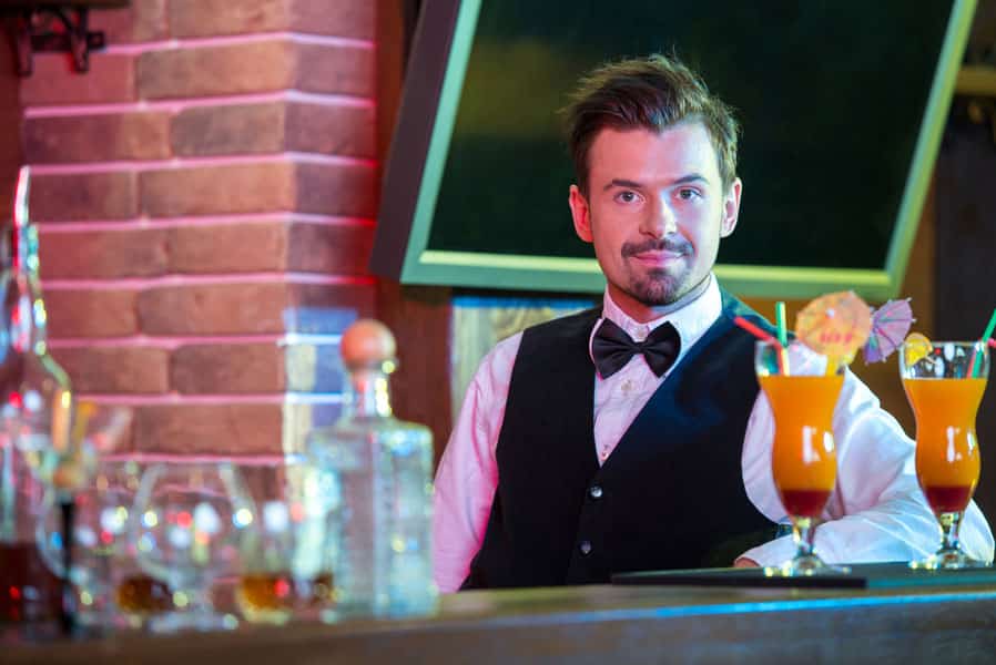 barman making cocktail for friends