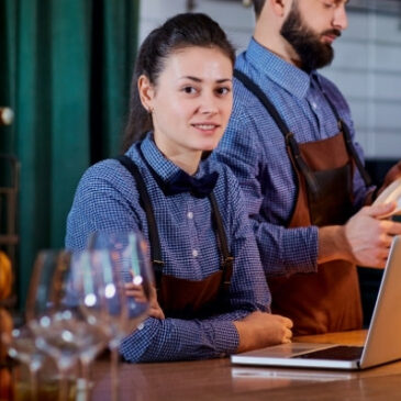 woman bartender on laptop at bar counter, cover letter