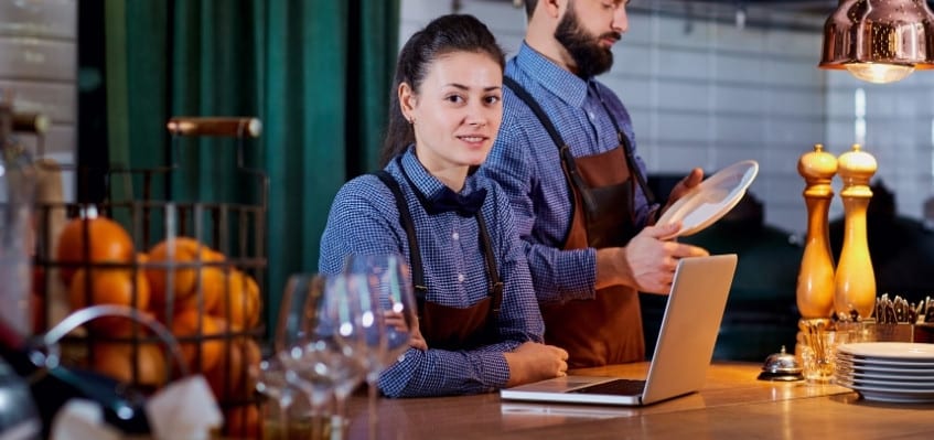 woman bartender on laptop at bar counter, cover letter