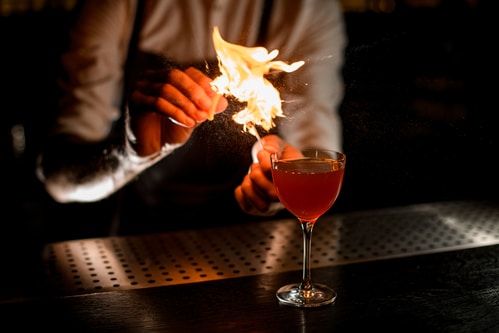 A server with a Texas TABC bartending license makes a flaming drink