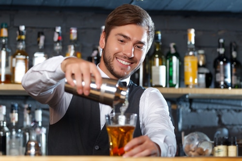 Handsome California bartender during work day pouring drink