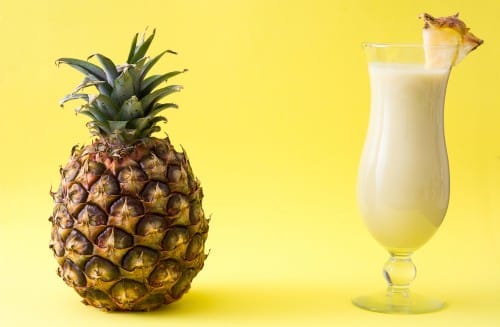 pina colada mixed drink with pineapple garnish