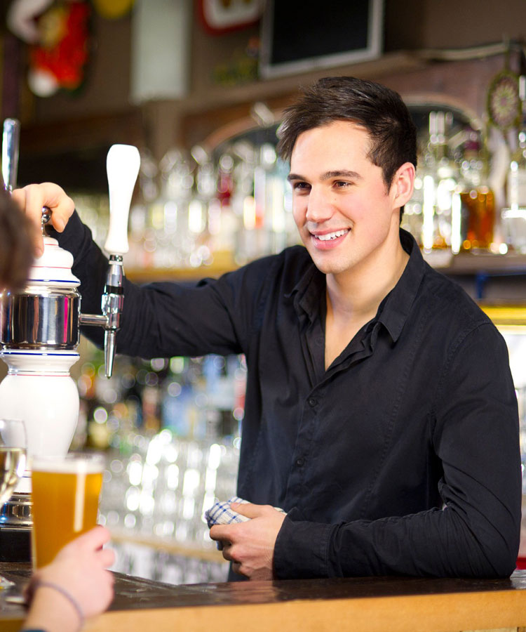 young bartender serving beer with his Kansas bartending license