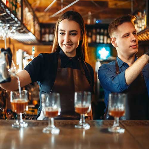 male and female bartender at the bar counter in restaurant